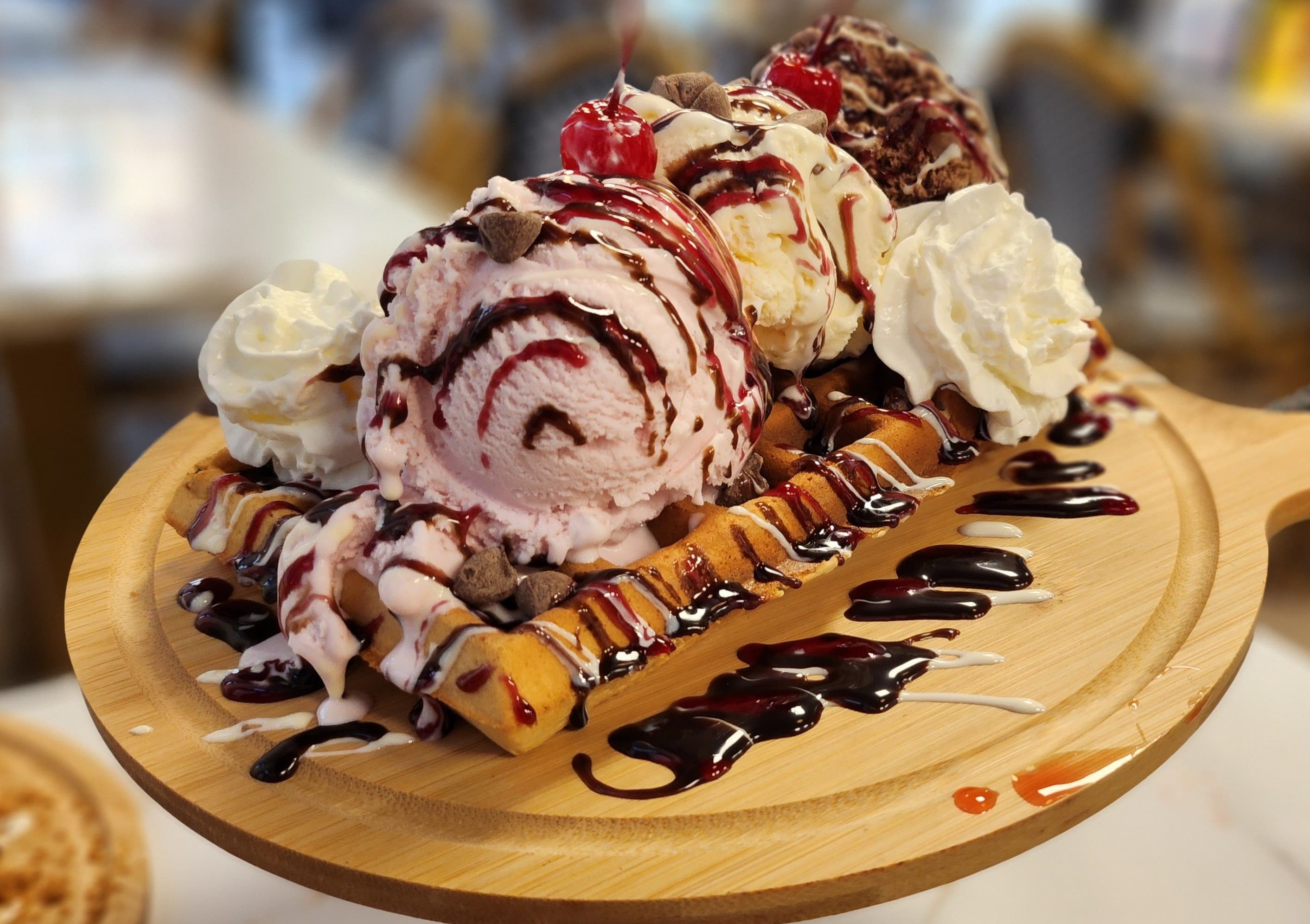 Waffle loaded with ice cream and toppings.